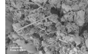 Elektronenoptische Aufnahme einer Dichtwandmasse mit wolkigen Tonmineralen und nadeligen Hydratationsprodukten des Zements
